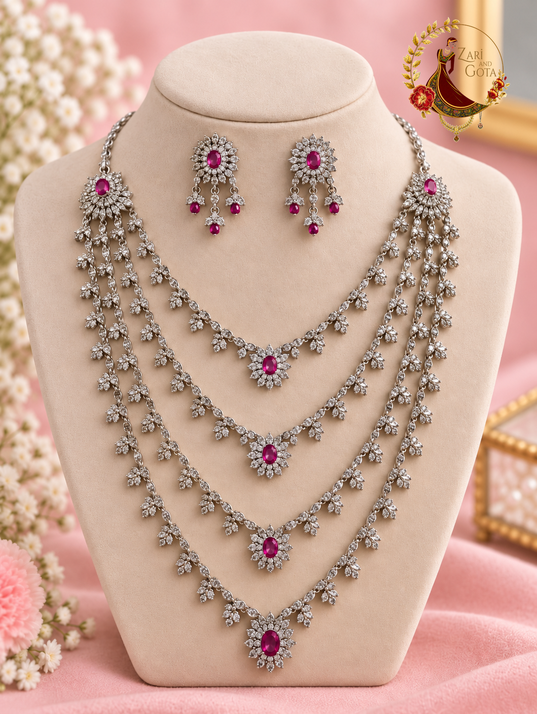 Four-layer silver-tone American diamond necklace with ruby red ovals and statement earrings on a display bust, Zari and Gota UK