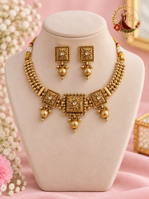 Antique gold-finish temple choker with carved square medallions and hammered ball drops, with matching studs, on a display bust, Zari and Gota UK