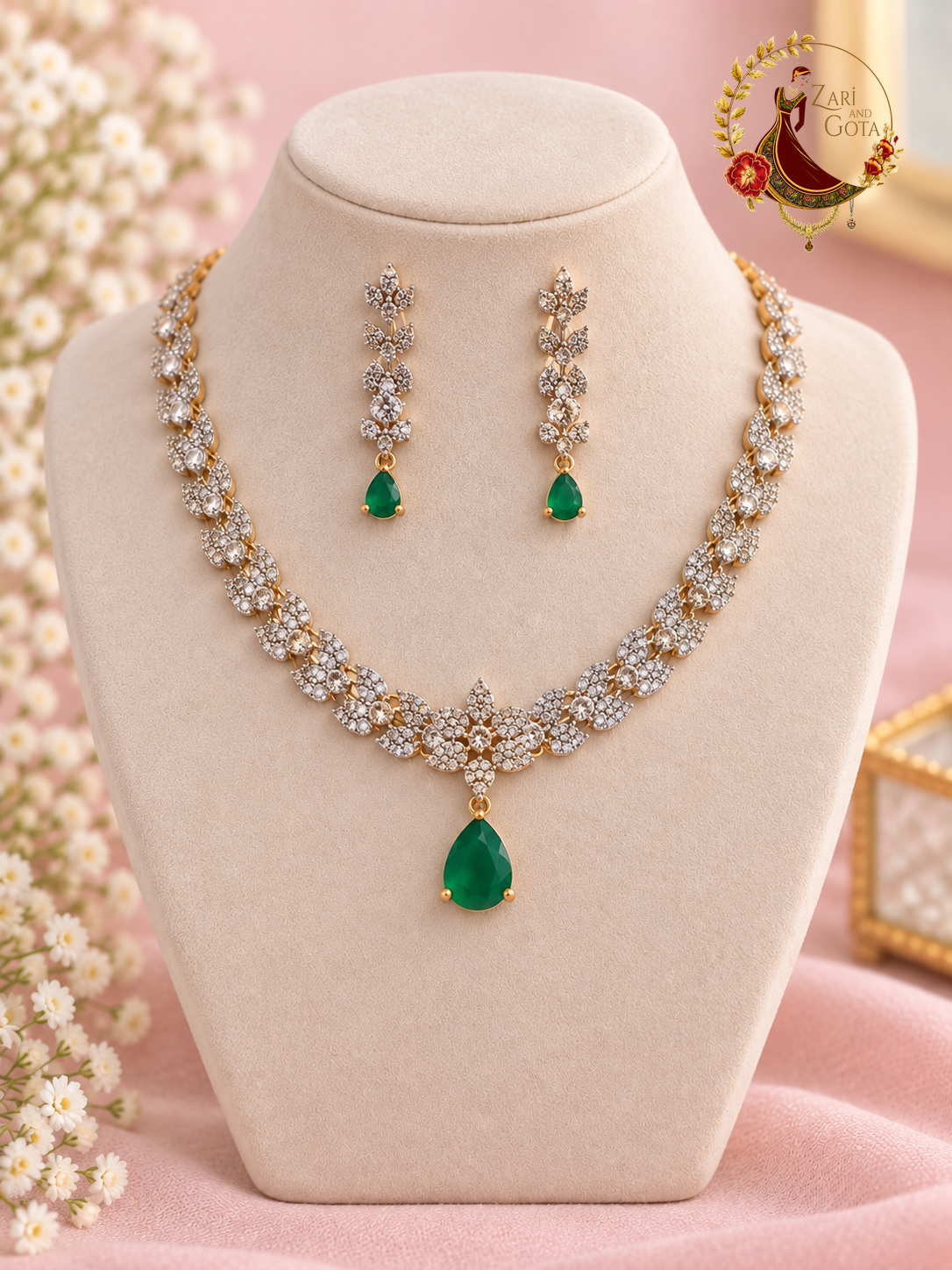 Gold-tone American diamond leaf-cluster necklace with emerald green pear drop and matching earrings on a display bust, Zari and Gota UK