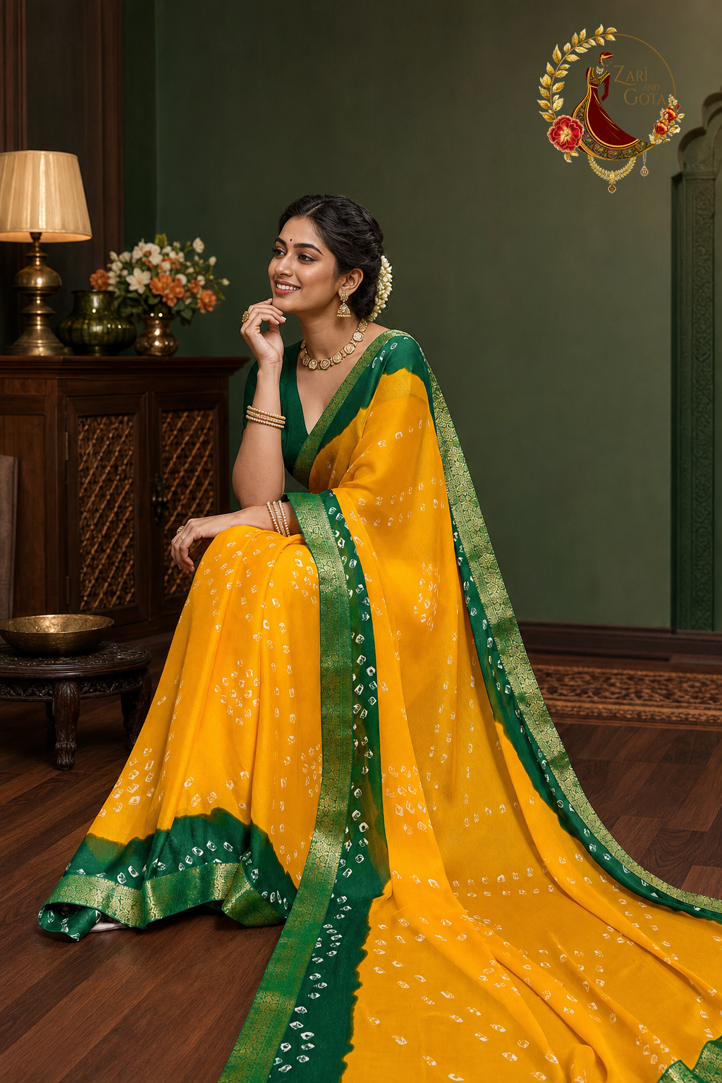 Seated view of marigold yellow bandhani saree with deep green zari border