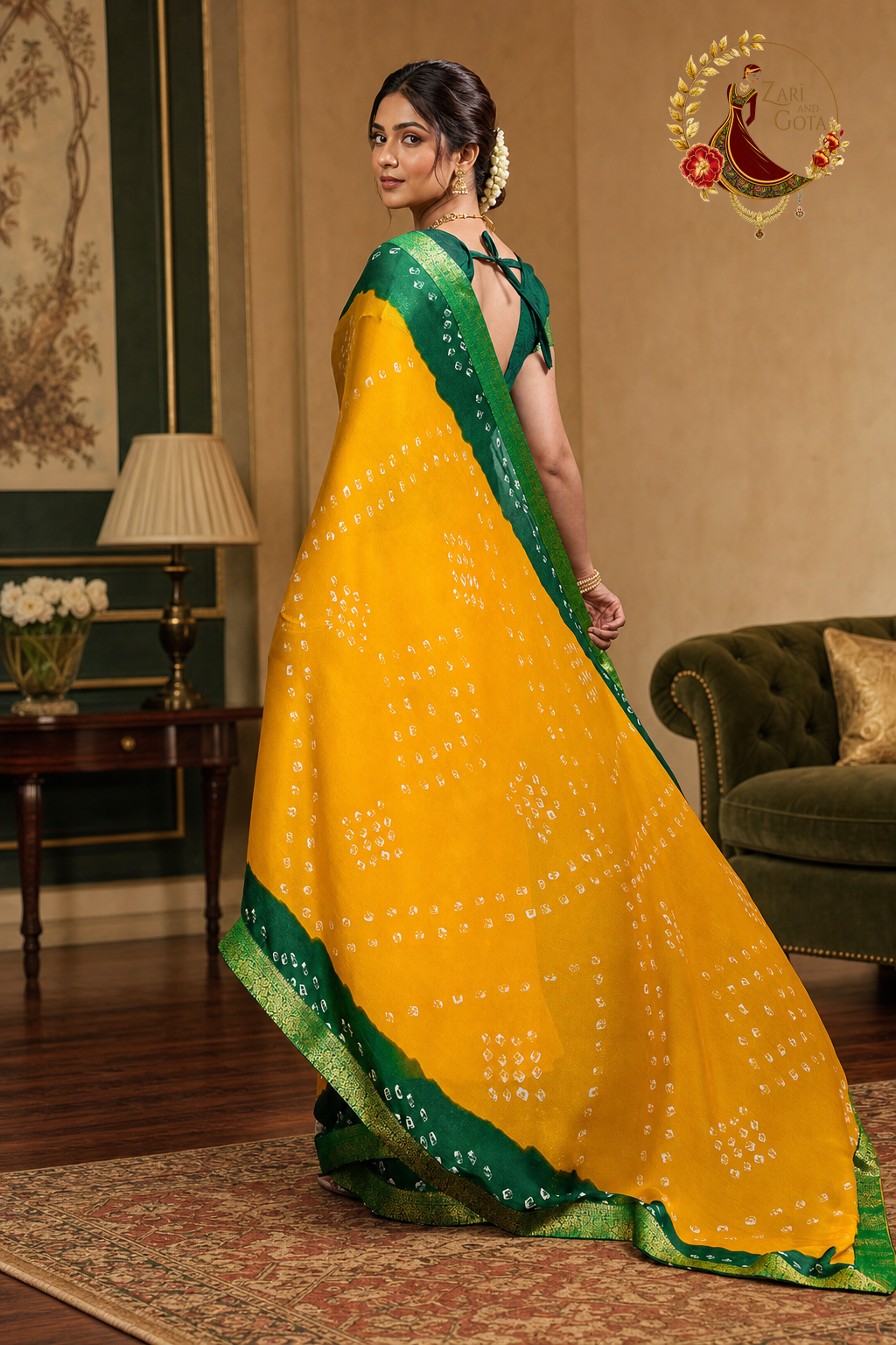 Yellow bandhani georgette saree pallu held out showing the green zari hem