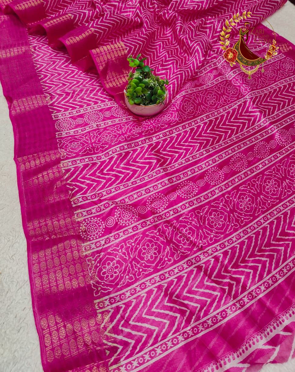 Folded magenta pink cotton silk saree showing the woven gold zari border blocks