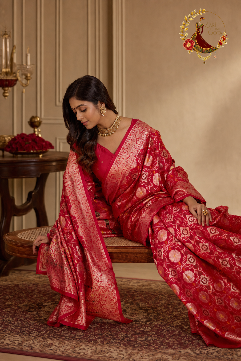 Seated view of red ghatchola zari saree showing pallu and border detail