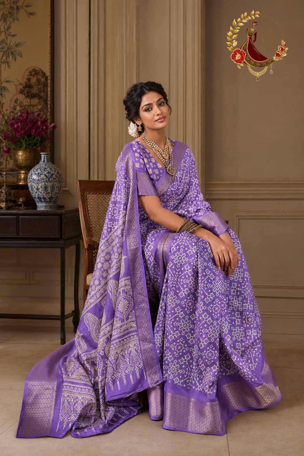 Seated view of lavender cotton silk saree showing ivory paisley pallu