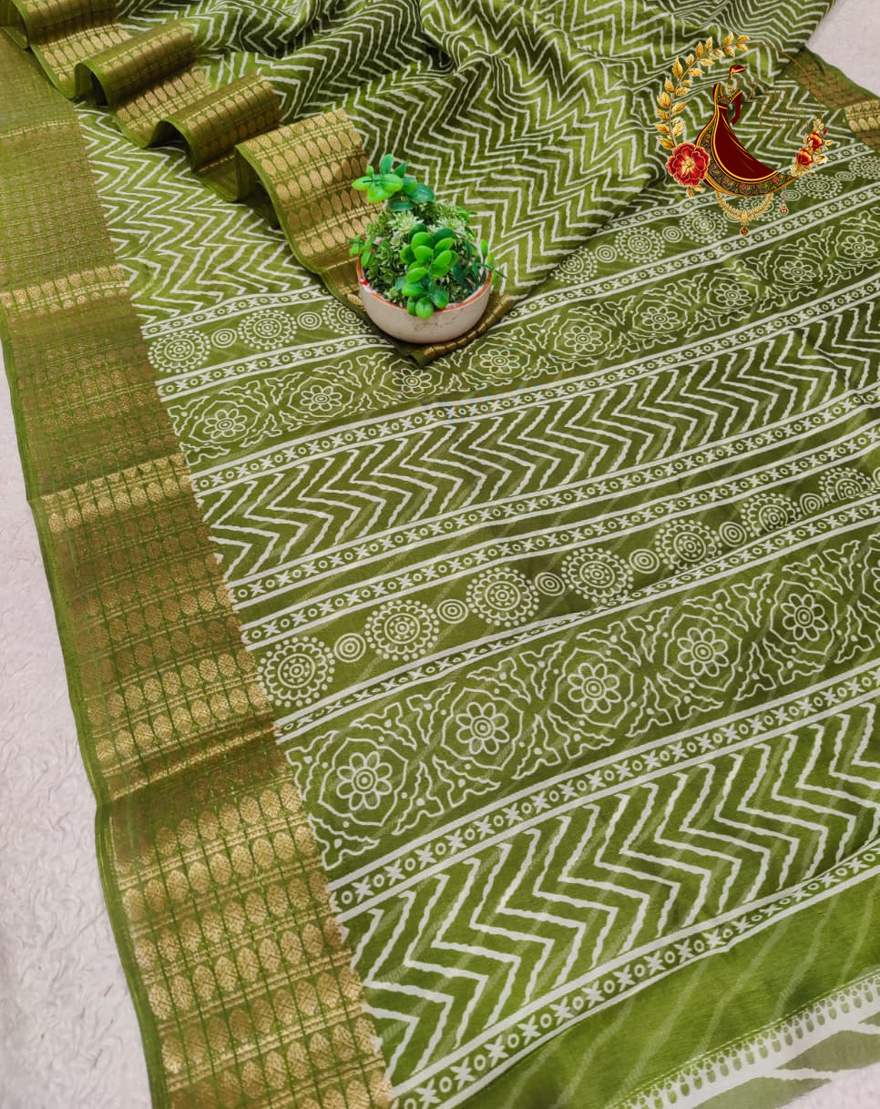 Folded olive green cotton silk saree showing the woven gold zari border blocks