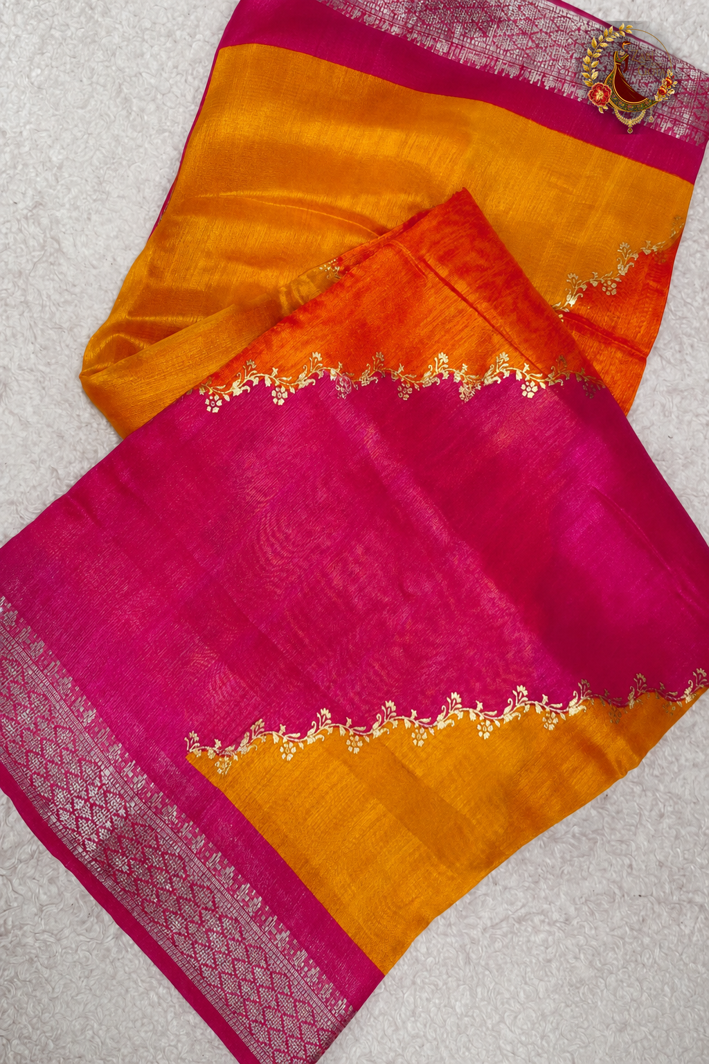 Cotton silk saree folded showing pink and yellow colour blocking with gold scalloped embroidery
