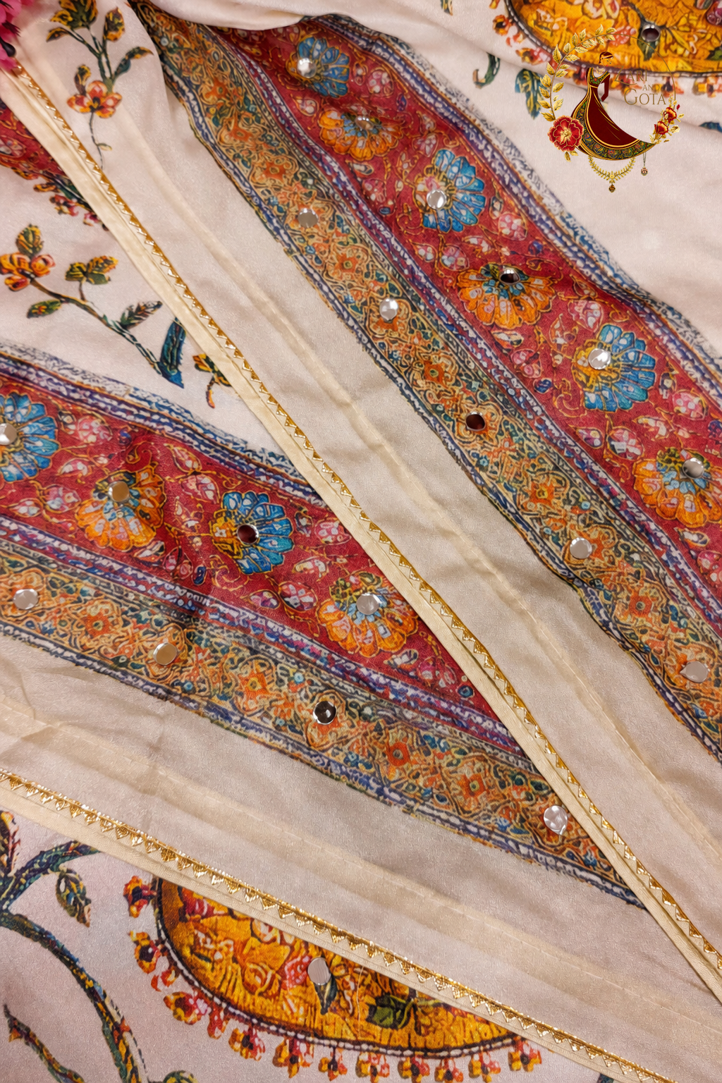 Close detail of mirror accents and printed border on ivory georgette