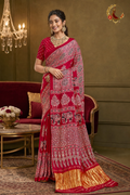 Deep red Gaji silk ajrakh saree with ivory elephant print and gold tissue border, worn by a model
