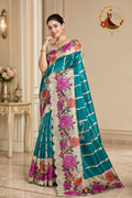 Teal tissue silk floral print saree with scalloped cut-work border, worn by a model, front view