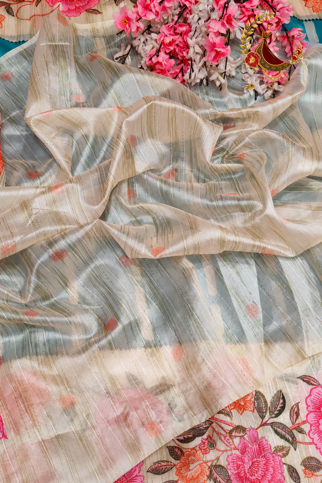 Ivory tissue silk blouse piece with small floral print, included with the teal saree