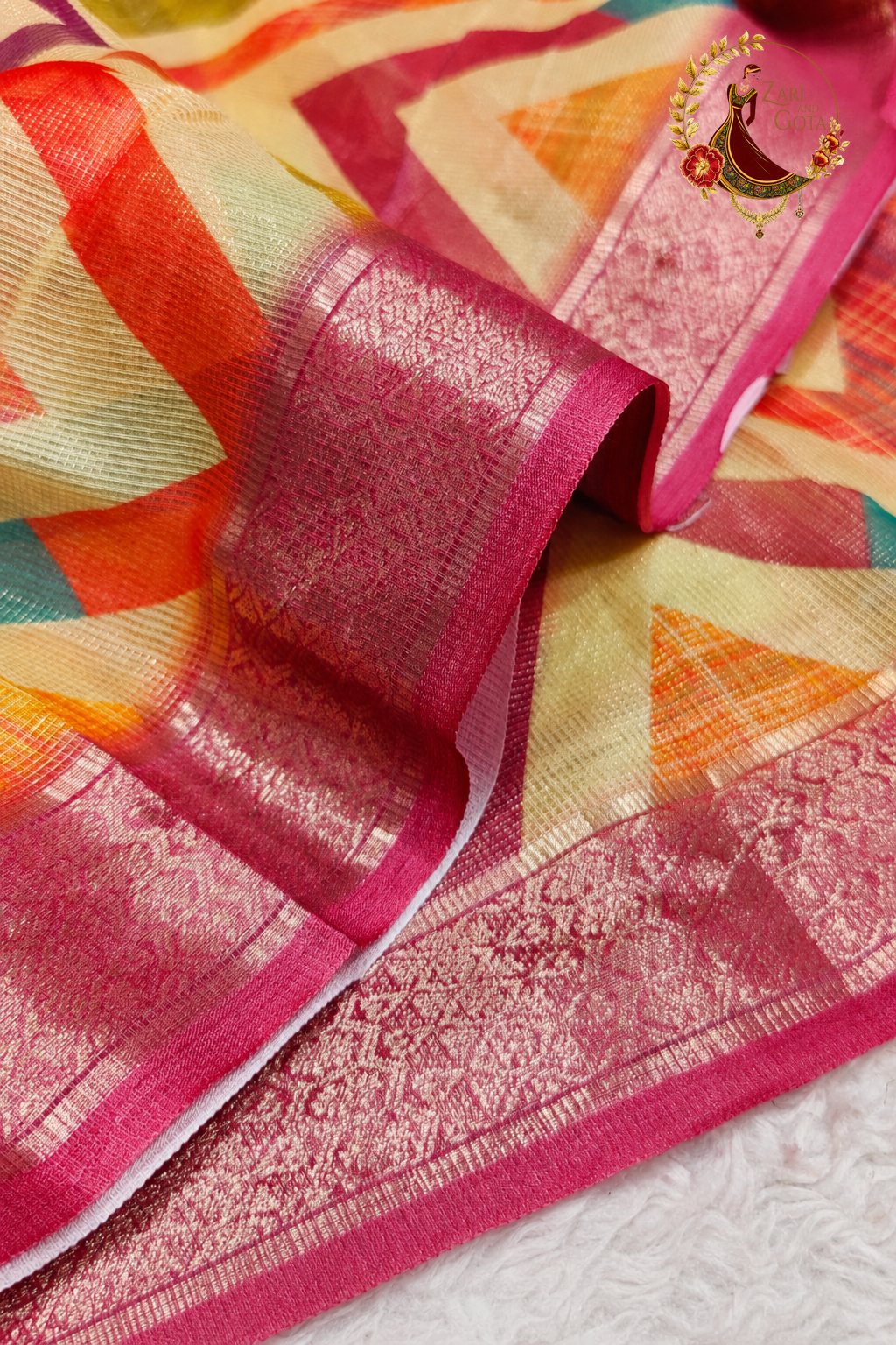 Close detail of silver zari woven border on chevron print tissue