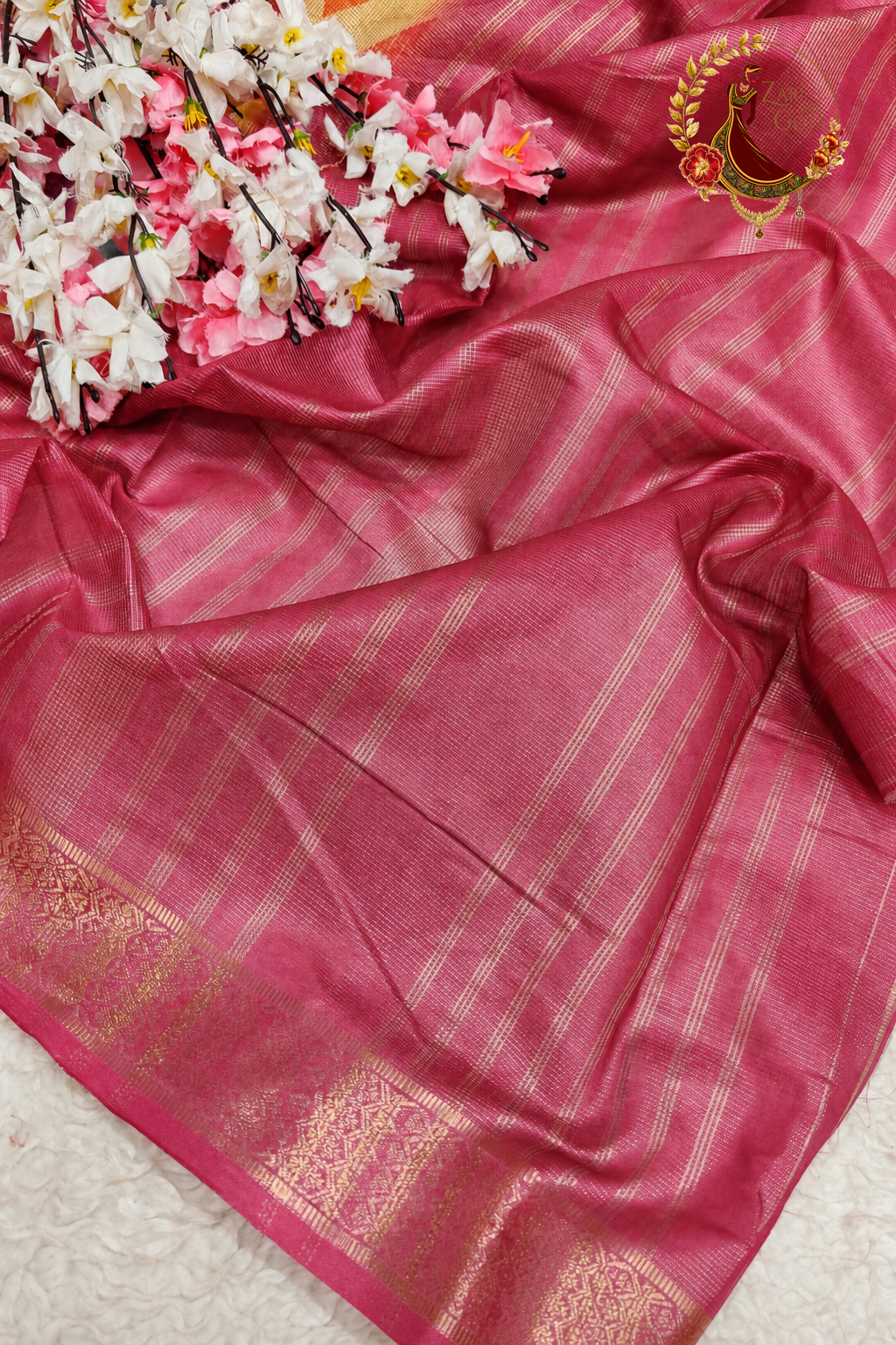 Pallu detail showing broad silver zari woven bands on rose pink tissue