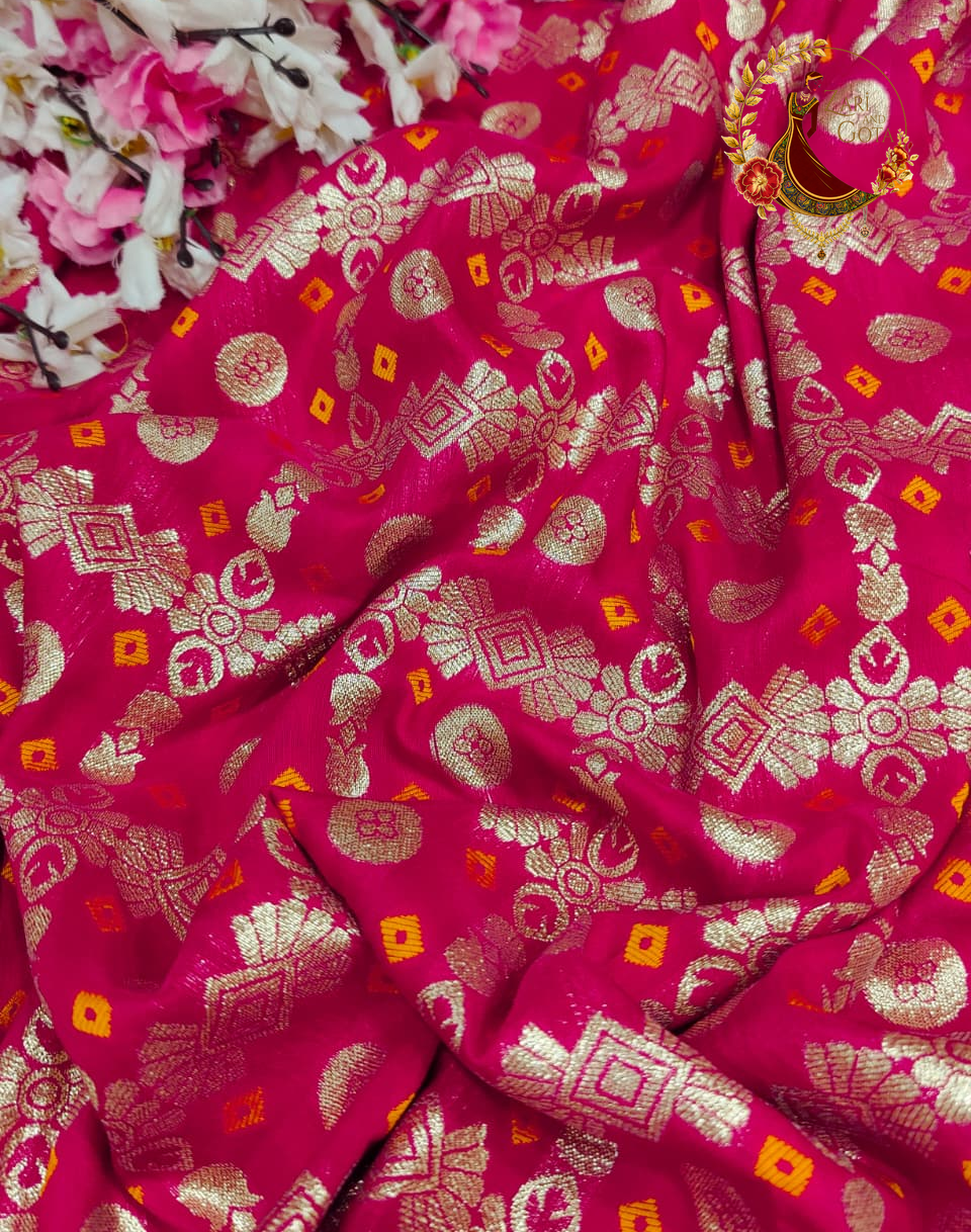 Close view of gold zari discs and orange-centred squares on rani pink silk