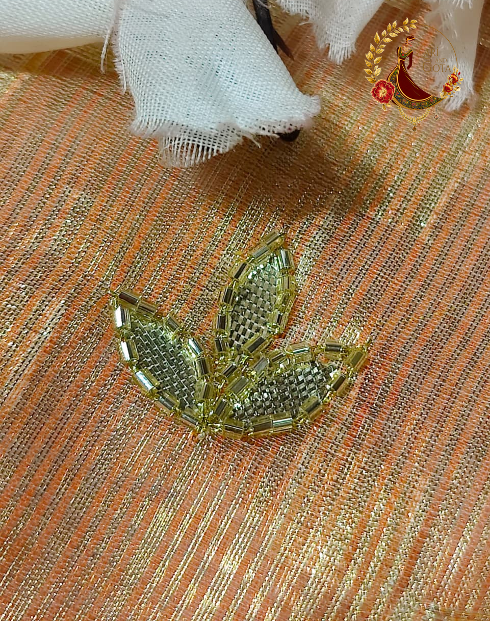 Close detail of individually stitched cut glass beads forming a leaf motif